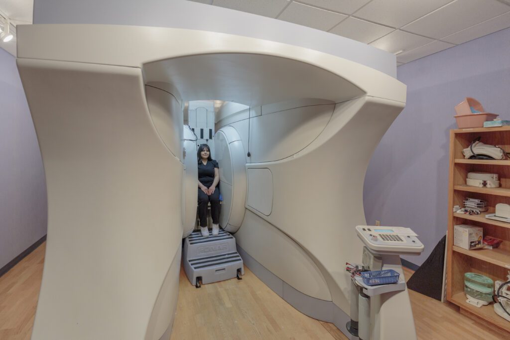 Image of a woman in a Fonar Upright MRI machine for seated or standing MRI's in Albuquerque